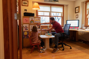 Father Hanging childs artwork in his hygge home office 