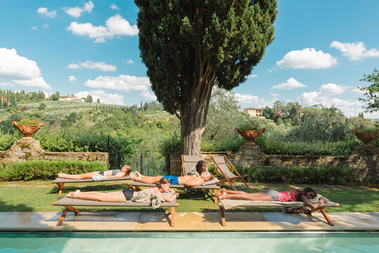 Diverse friends resting by a pool - Powered by Adobe