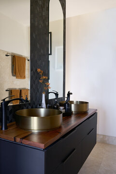 Ensuite with black cabinetry and copper basins