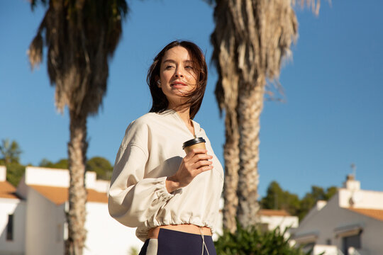 sportive woman enjoying her take away coffee