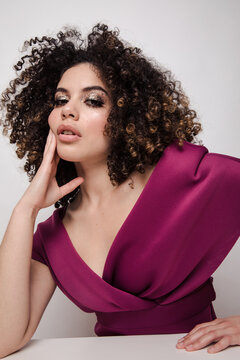 Model in maroon silk dress with glittery makeup on
