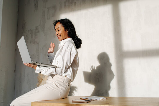 Smiling black woman having video chat on laptop