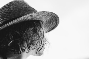 Mujer con sombrero de perfil, en blanco y negro.
