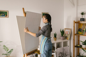 Woman preparing canvas for painting at home