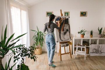 Anonymous artist in art studio painting on canvas