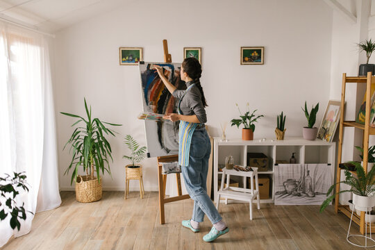 Artistic woman painting in home studio