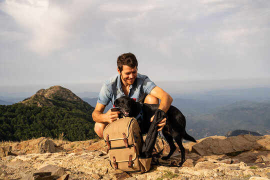 Portrait of happy man with backpack and  dog in nature
