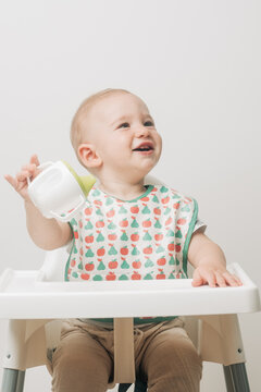 Smiling Baby Drinking Milk From A Sippy Cup 