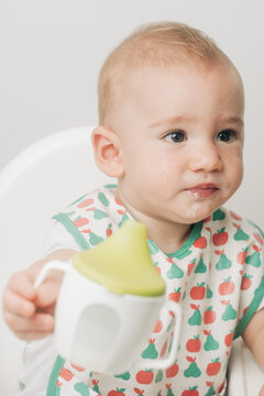 Baby Drinking From A Sippy Cup Wearing Bib