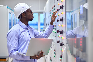 Engineer man with laptop in production control room 