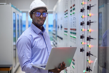 Engineer man with laptop in production control room 