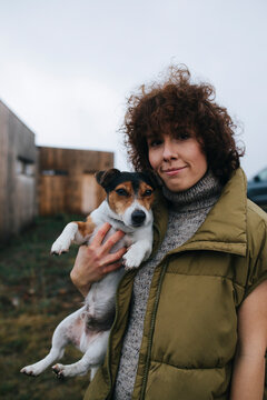 Portrait of Beautiful Woman Holding Dog Outdoors