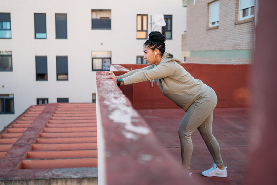Sportswoman stretching legs during training