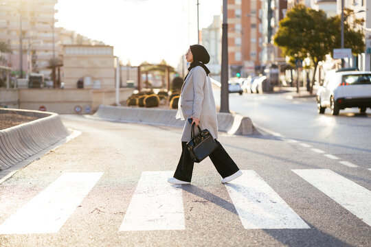 Trendy woman walking on pedestrian crossing