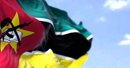 Detail of the national flag of Mozambique waving in the wind on a clear day - obrazy, fototapety, plakaty
