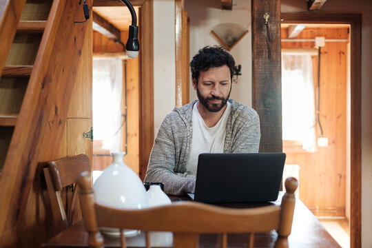 Man browsing laptop at home