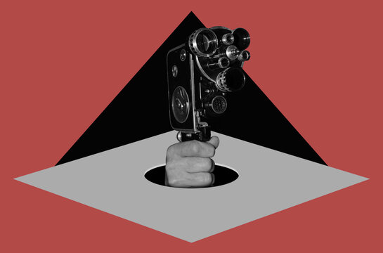 Hand with movie camera out of hole