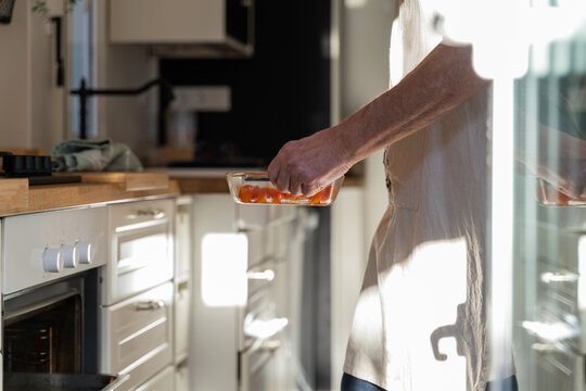Senior man placing cooking tray inside ove