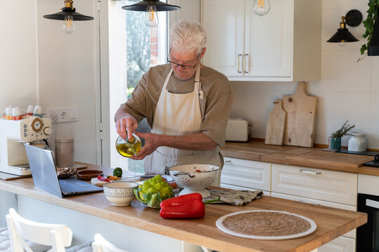 Senior man cooking preparing healhty meal in kitchen
