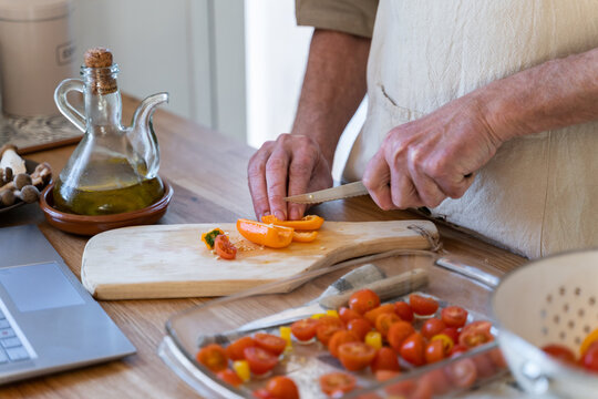 Senior man cooking preparing healhty meal in kitchen