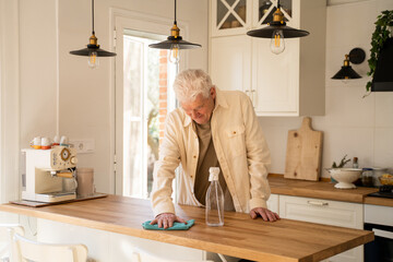 Active Senior man cleaning up kitchen counter top 