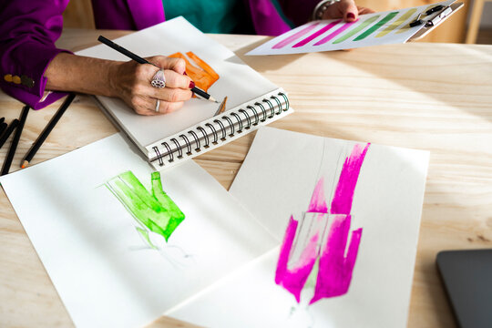 Fashion designer drawing jacket on sketch book