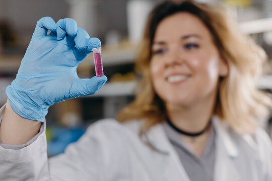 Smiling scientist with test tube of sample