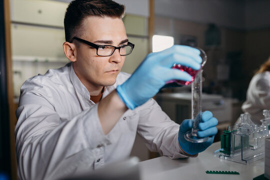 Scientist adding reagent in test tube in lab