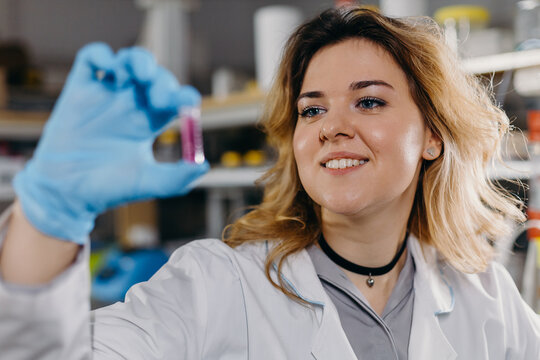 Female scientist analyzing test tube with liquid sample