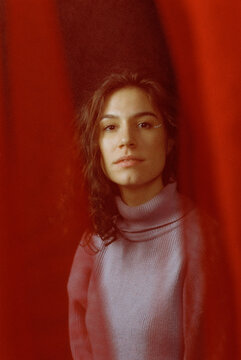 Portrait of a young girl behind a red curtain