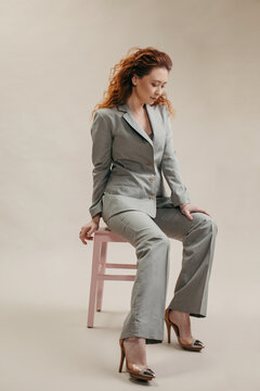Woman in gray suit sitting on chair
