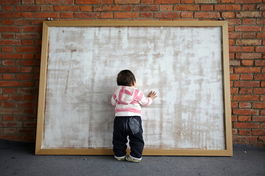 Cute little Asian baby in front of big picture frame
