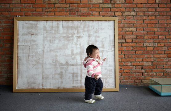 Cute Little Asian Baby In Front Of Big Picture Frame