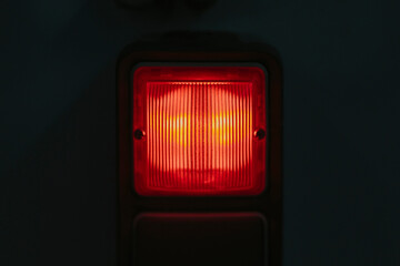 Red alarm light on black background