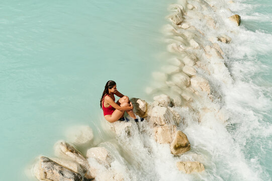 Woman sitting in scenic river rapids