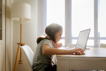 Little girl using a laptop at home
