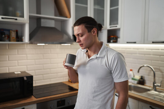 A Man Drinking A Cup Of Coffee