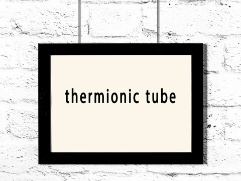 Black frame hanging on white brick wall with inscription thermionic tube