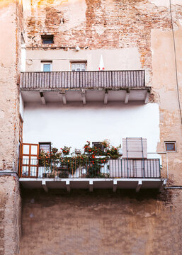 An ugly house with a lovely balcony with plants and flowers 