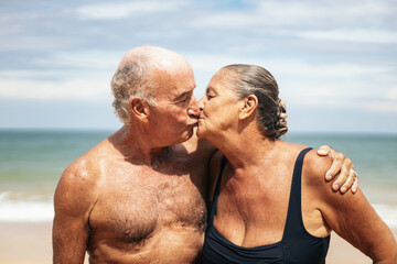 Portrait of an elderly couple kissing on the beach