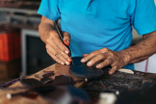 Anonymous shoemaker working the leather