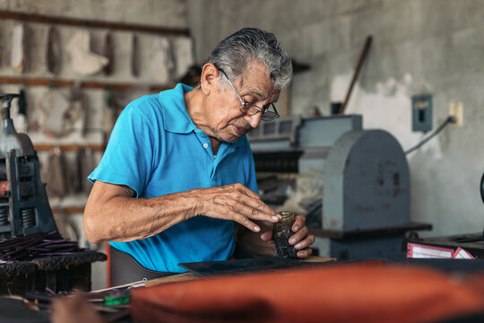 Older shoemaker working in his workshop