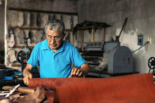 Hispanic senior shoemaker working in his workshop