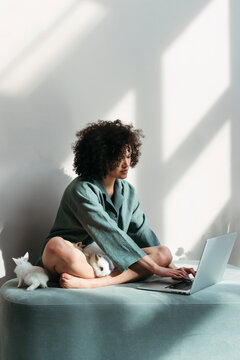 Mixed-race young woman using laptop.