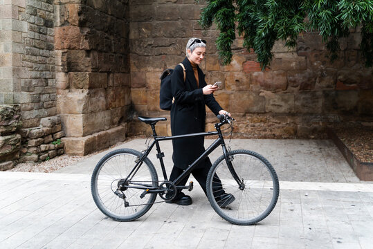 Female Bicyclist Using Smartphone In Evening