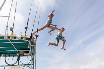 Best Friends Jumping off boat into water while swimming