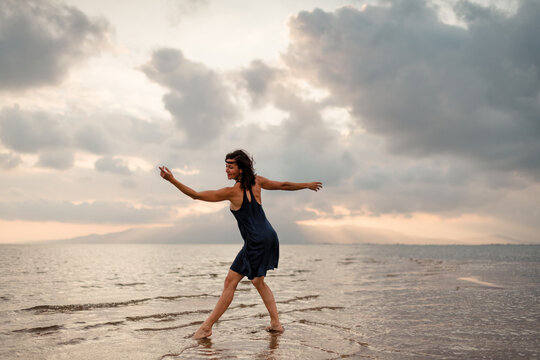 Woman dancing on paradisiac beach shore