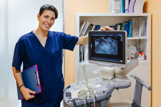 Gynaecologist posing next to an ultrasound unit