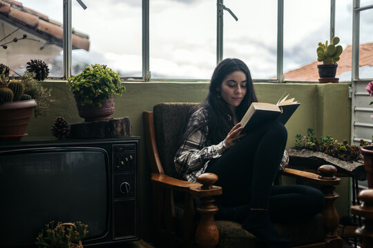 Young woman reading in a vintage room