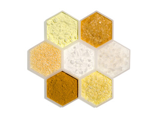 Chemical ingredient in hexagonal molecular shaped container. Sulfur Powder, Carnauba Wax, Candelilla Wax, Cetyl Esters Wax, Flake Salt, Curcuma Powder and Sodium Sulfide Flakes.